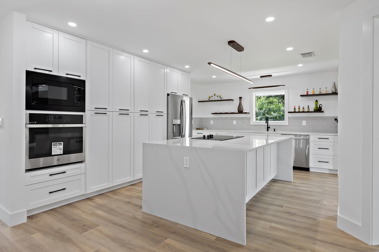 Remodeled kitchen with a quartz waterfall island